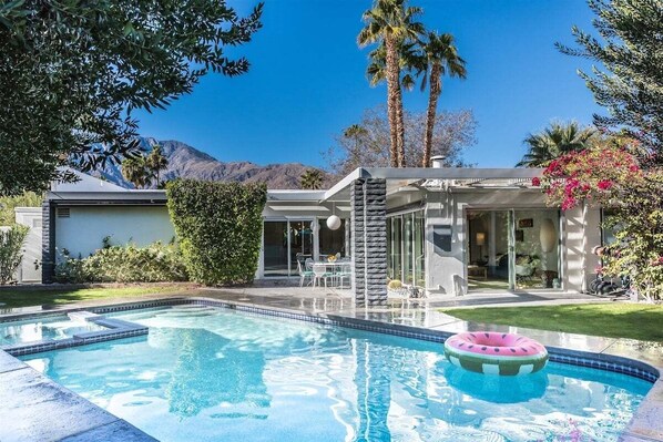 A modern house with a swimming pool, a patio with outdoor furniture, and a mountain view. - The Elrod - Exclusive Vacation Home with Pool & Spa (Palm Springs)