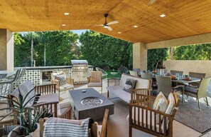 An outdoor patio with a grill, seating area, and fire pit. - Palm Springs Modern Retreat - Ultimate Entertainment Escape: Pool, Spa & Game Room in Palm Springs (Palm Springs)
