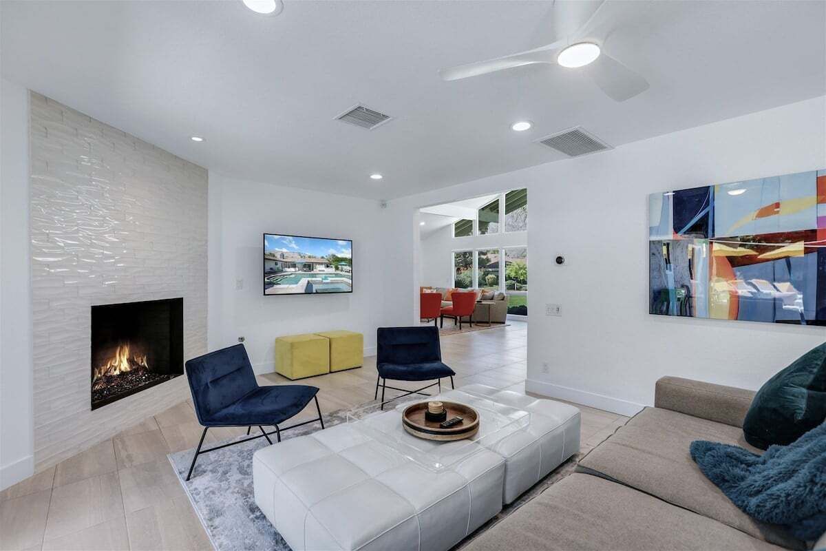 A modern living room with a fireplace, comfortable seating, and artwork on the walls.