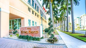 Un edifici amb un rètol que diu "King David" i palmeres al primer pla.