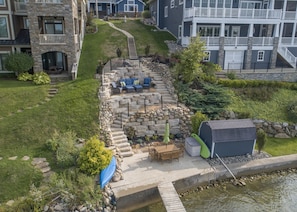 A residential area with a stone patio, outdoor furniture, and a small pond.