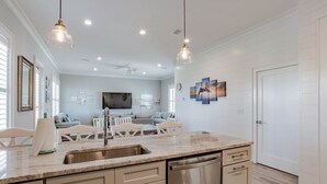 A modern kitchen with a central island, stainless steel appliances, and pendant lighting.