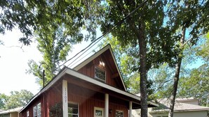 A two-story wooden cabin with a porch and a gravel driveway. - The Cedar Shack near Lake Conroe (Montgomery)