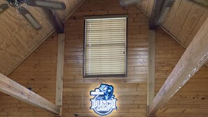 A wooden interior with a white door, a neon sign, and two windows. - The Cedar Shack near Lake Conroe (Montgomery)