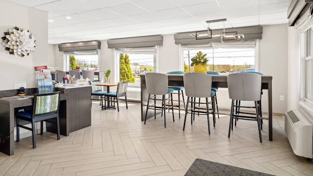 A modern kitchen with a central island, bar stools, and a dining table.