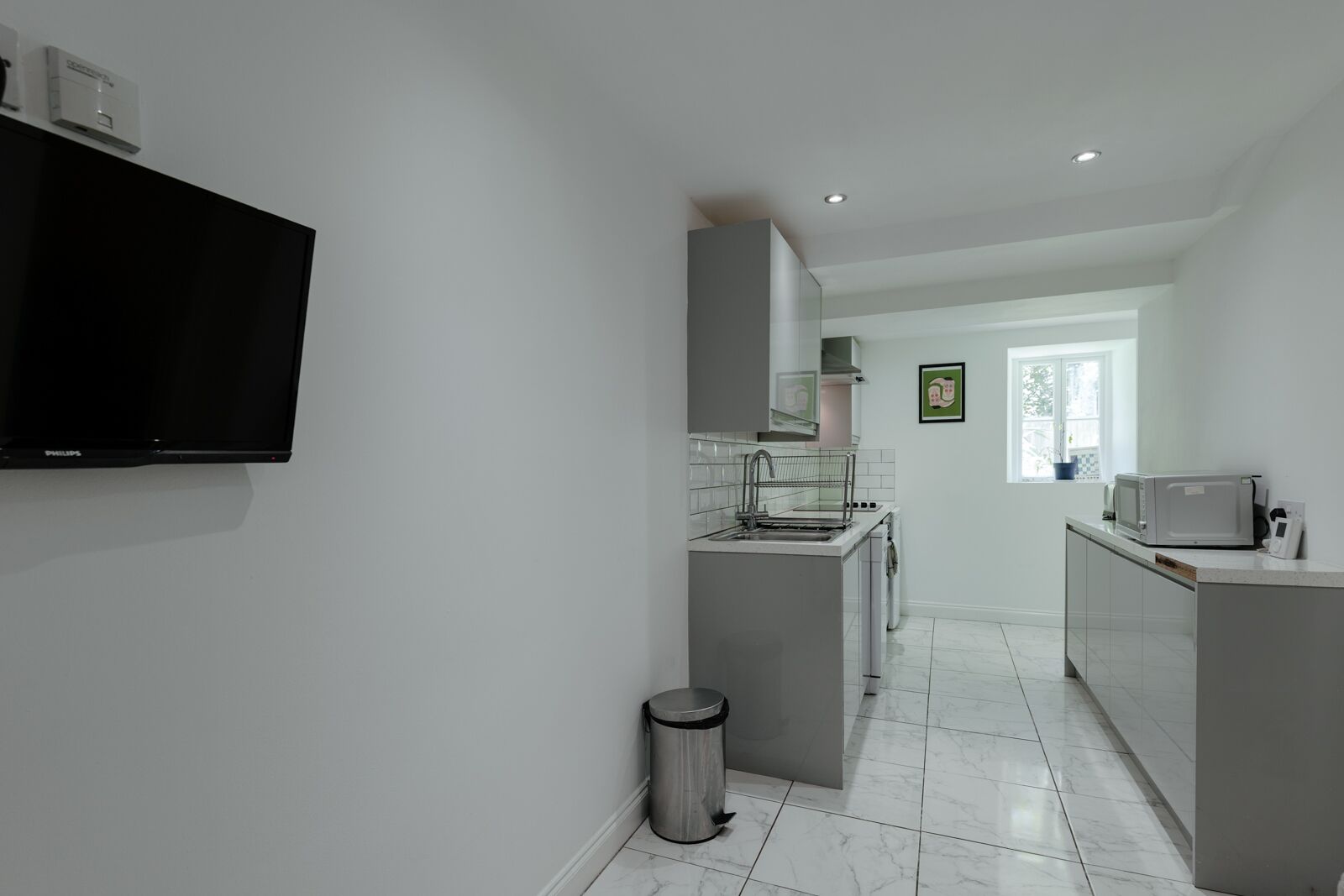 A modern kitchen with a built-in dishwasher, a microwave, and a sink.