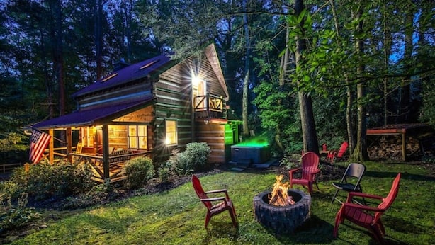 A rustic cabin with a porch, a fire pit, and outdoor seating. - Twin Creeks Refuge, a log cabin, Pet friendly (Maggie Valley)