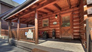 A wooden cabin with a covered porch, a sign for 'Aunt Bug's Cabin Rentals LLC', and a mailbox. - Incredible Vibes & Views #204 (Sevierville)