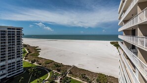 Un hotel frente a la playa con varios balcones con vistas al océano.