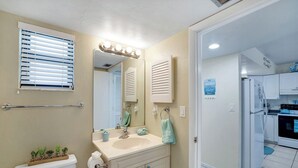 Ein Badezimmer mit Toilette, Waschbecken, Spiegel und Handtuchhalter.