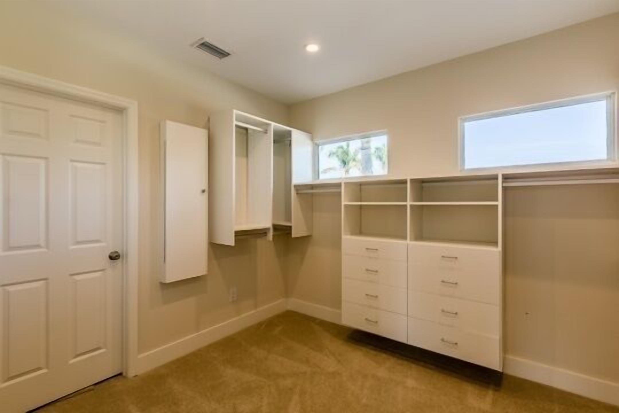 A room with a closet, a door, and a window.