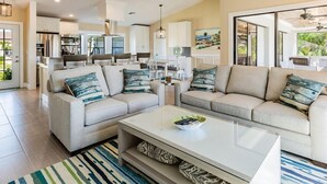 A modern living room with two sofas, a coffee table, and a dining area in the background. - A perfect home to fully enjoy all of Marco Island (Marco Island)