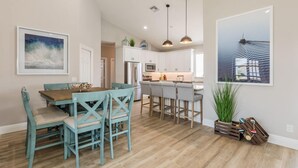 A modern kitchen with white cabinets, a central island, and pendant lighting. - Beautiful 3Bdr Home located in the heart of Marco. (Marco Island)