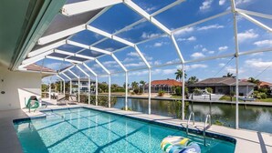 A swimming pool with a view of a body of water and houses in the background. - Beautiful 3Bdr Home located in the heart of Marco. (Marco Island)