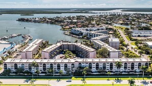 Ein großes Hotel mit Innenhof, umgeben von einer Marina und einer Brücke.