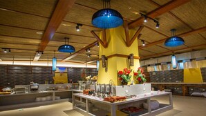 A buffet area with a central island, multiple serving stations, and hanging blue pendant lights. - Wyndham Xishuangbanna South Resort (Xishuangbanna Dai)