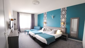 A hotel room with a large bed, a desk, a chair, a TV, and a bathroom.