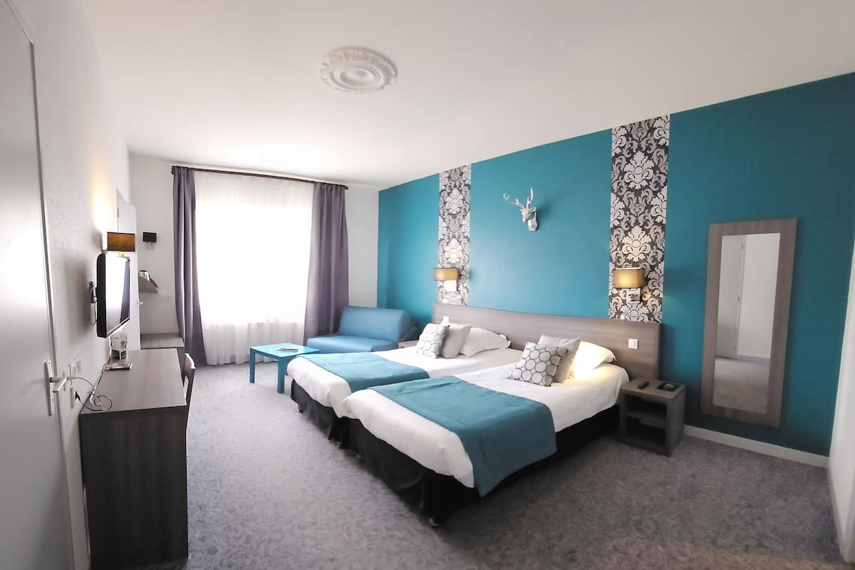 A hotel room with a large bed, a desk, a chair, a TV, and a bathroom.