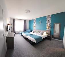 Habitación de hotel con una cama grande, un escritorio, una silla, un televisor y un baño.