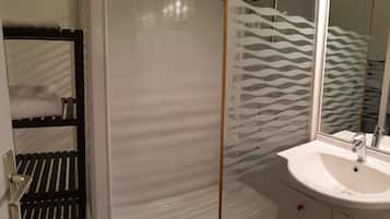 Un baño con un lavabo blanco, un espejo y una ducha con un diseño ondulado.