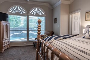Relax in this classic bedroom with a large bed, flat-screen TV, and scenic view.