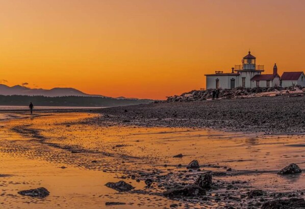 Un paysage côtier avec un phare et un terrain rocheux.