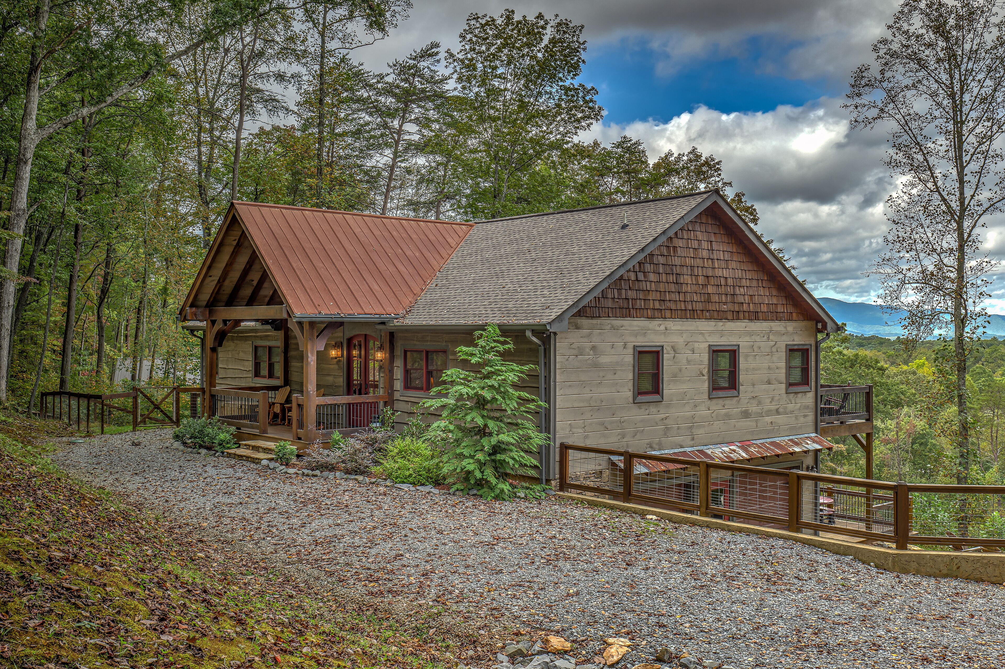 Une cabane avec une façade en bois, une véranda et une allée gravillonnée.