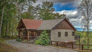 Een chalet met houten gevel, een veranda en een grindpad.