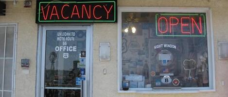 A motel with a neon sign indicating vacancy and an open window.