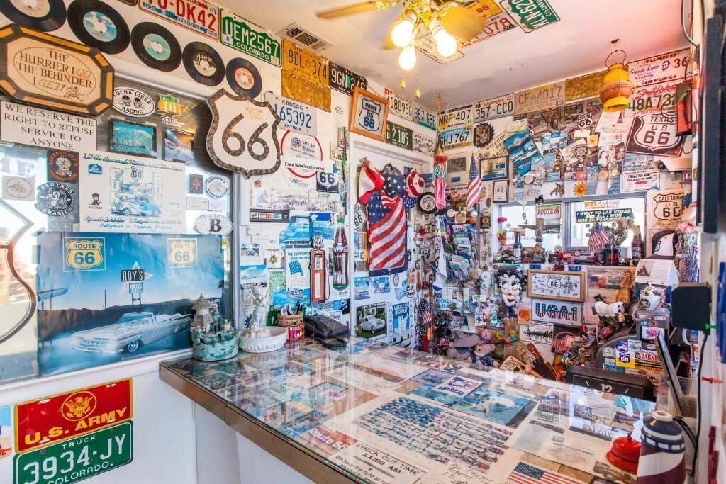 A room filled with memorabilia and collectibles, including road signs, vintage posters, and various souvenirs.