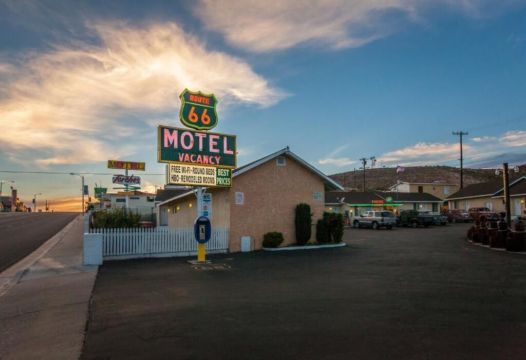 A motel with a sign indicating a vacancy, Route 66, and amenities like free Wi-Fi, round beds, and best remodeled rooms.