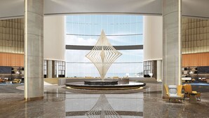 A spacious lobby with a central water feature, large windows, and modern furnishings. - Sheraton Rizhao Hotel (Rizhao)