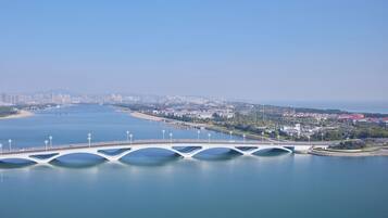 A white bridge with multiple arches over a calm body of water, connecting two land masses.