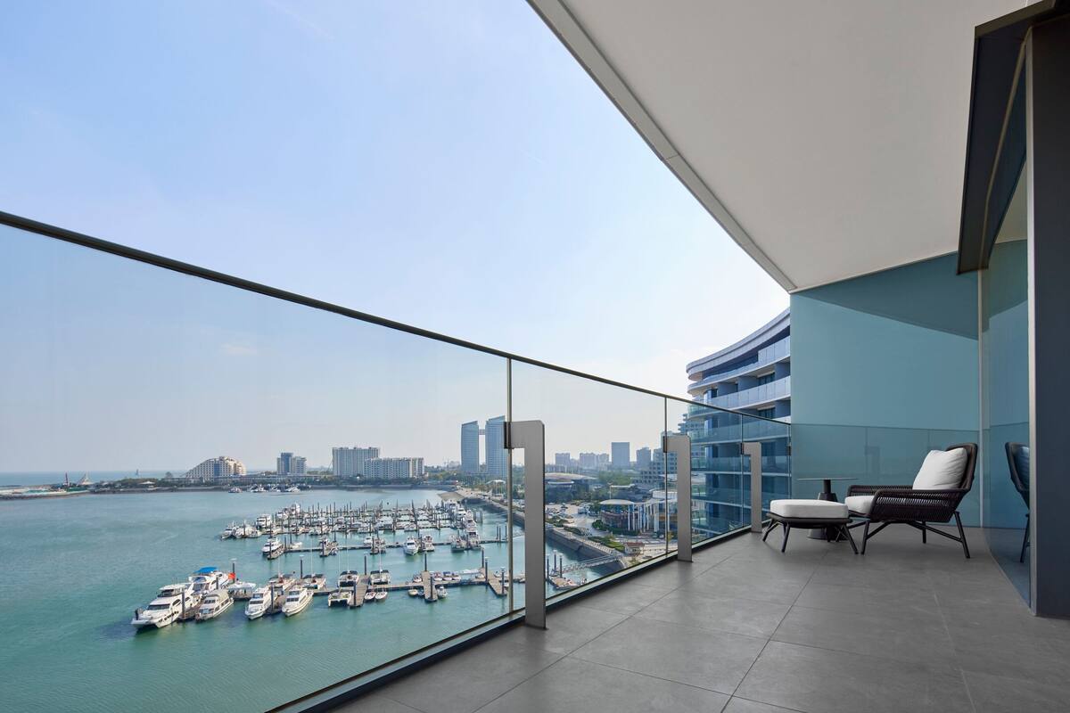 A balcony with a view of a marina and city skyline.