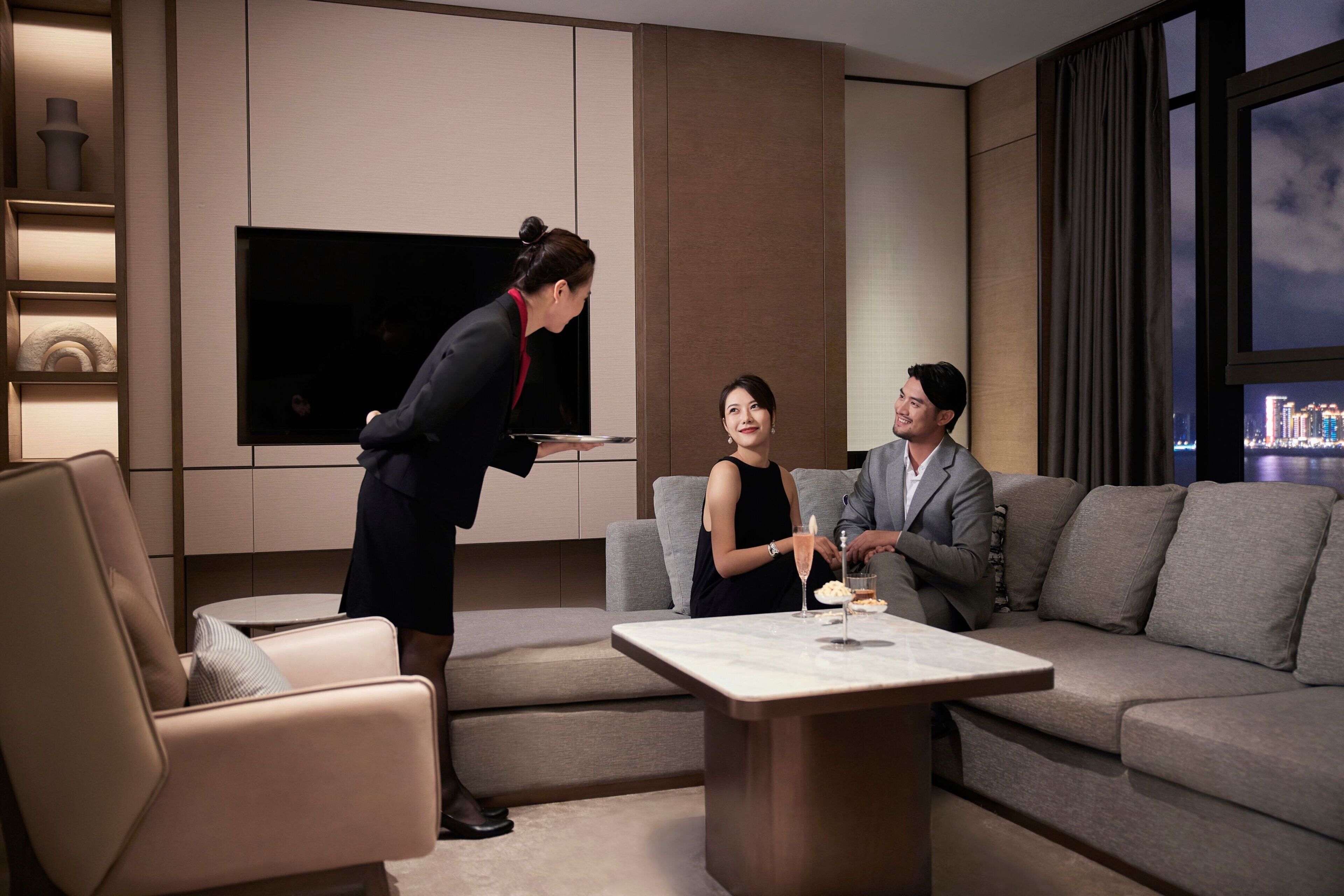 A modern living room with a sofa, a coffee table, and a flat-screen TV.