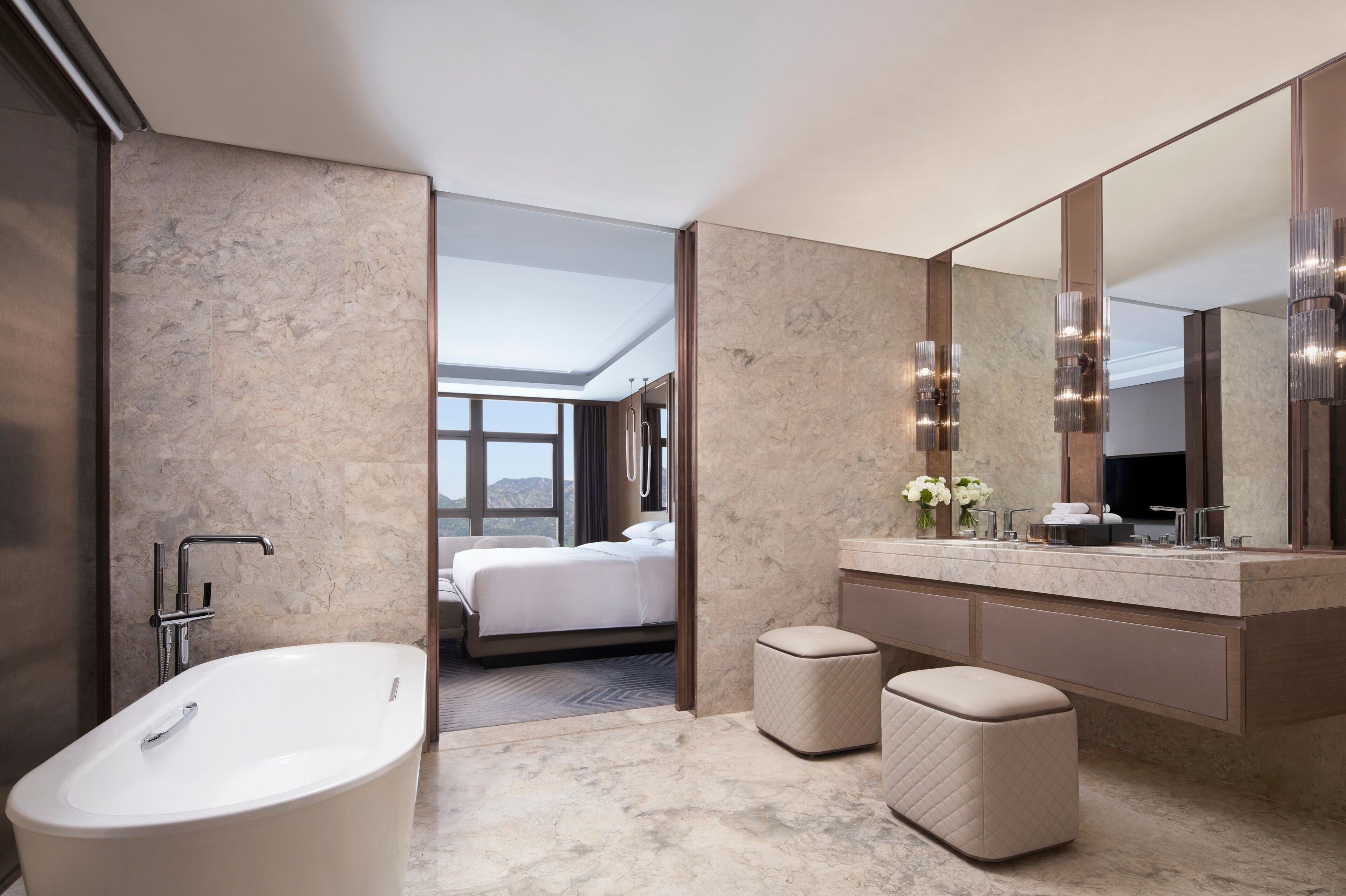 Une salle de bain moderne avec une baignoire sur pieds, un grand miroir et un meuble-lavabo doté d’un évier et d’un porte-serviettes.