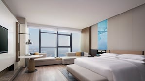 A modern hotel room with a large bed, a sofa, a small table, and a TV. - Jinhua Marriott Hotel (Jinhua)