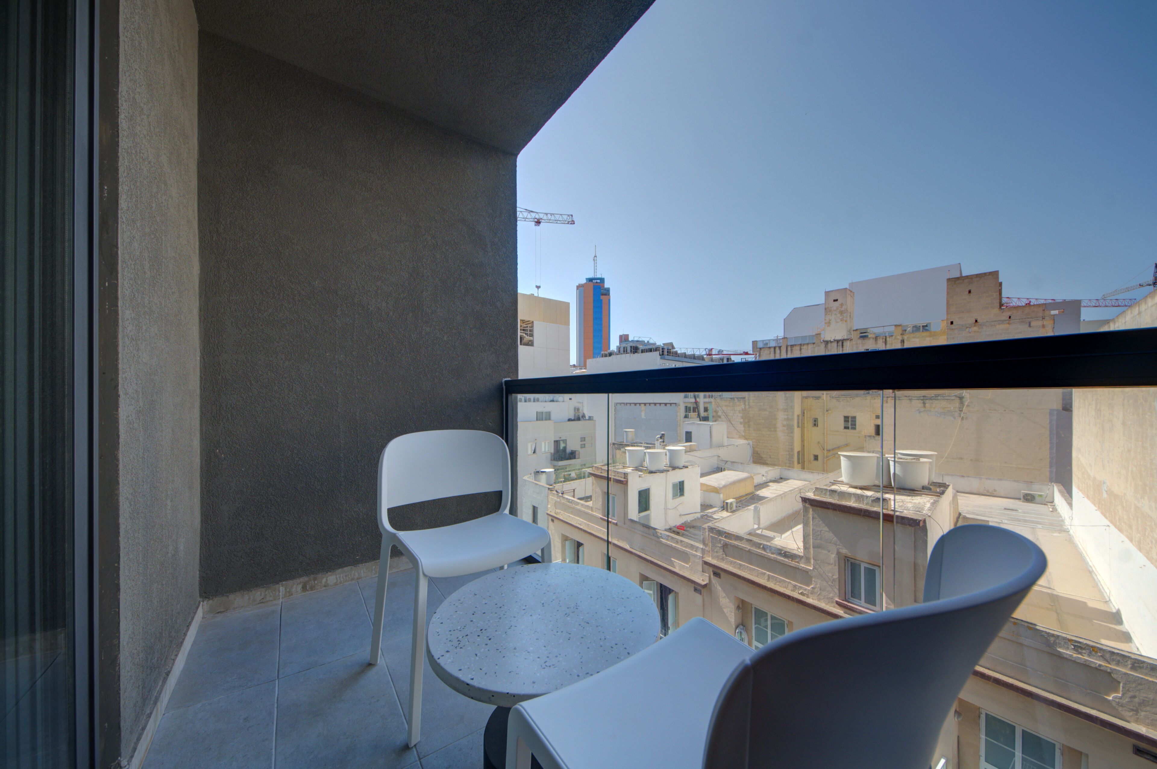 Un balcón con vistas a la ciudad, que incluye una mesa y dos sillas.
