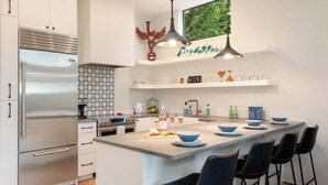 A modern kitchen with a large island, stainless steel appliances, and bar stools.