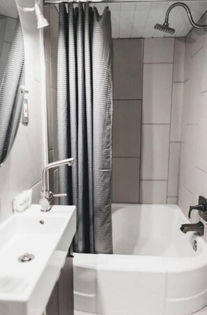 Bathroom features a bathtub and shower with a glass door.