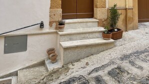 Un edificio con una puerta doble marrón, un arco de piedra y una pequeña escalera que lleva a la entrada.