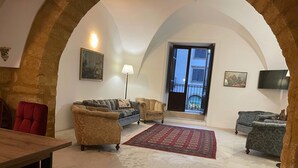 Una sala de estar acogedora con sofá, sillones, una mesa de madera y un tapete estampado.