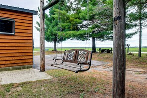 Una cabaña de madera con un banco al frente.