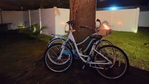 A bicycle parked under a tree with string lights.
