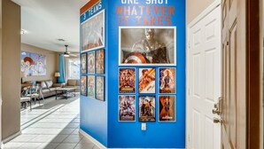 A hallway with a blue accent wall featuring movie posters and a '3 TEAMS' sign. - Windsor Hills Resort/2Bedrm Themed Condo (Kissimmee)
