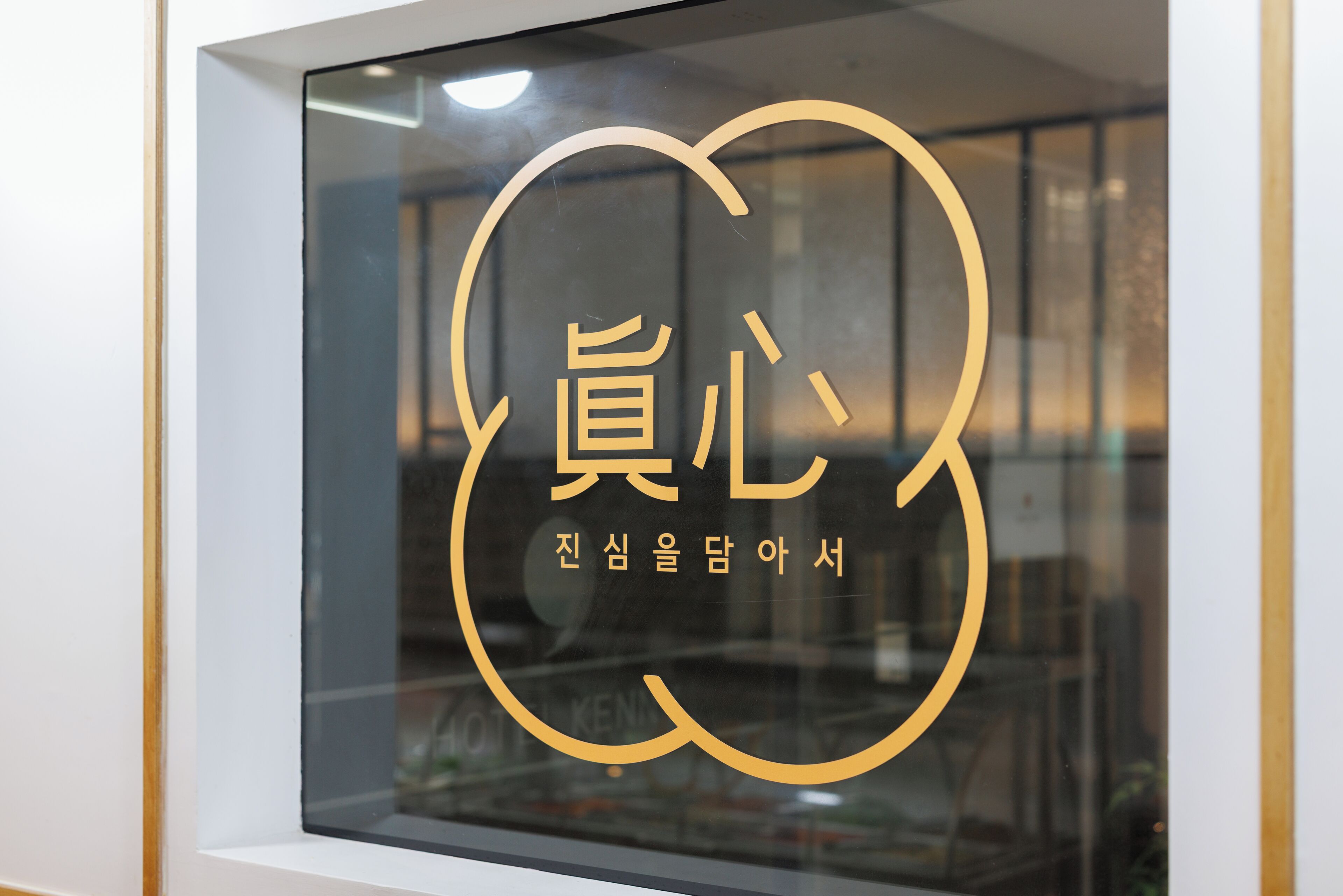 Una ventana con un logotipo y texto, probablemente representando un hotel o establecimiento comercial.
