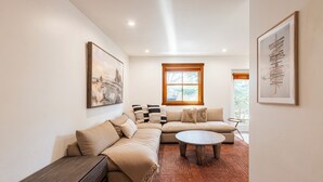 Una sala de estar con un sofá, una mesa de centro y una ventana con persianas.