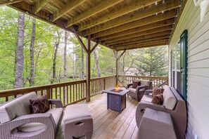 Eine überdachte Terrasse mit Korbmöbeln und einem Feuerkorb.