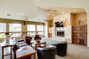 Relax in the lounge area with sofas, chairs, and a flat-screen TV, plus a fireplace and large windows.