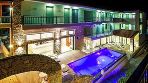 Ein mehrstöckiges Hotel mit Pool, Außenbereich und einer Fassade aus Stein.
